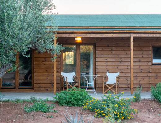 A wooden house with a green roof.