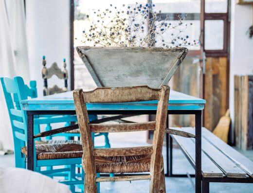 A blue table and chairs in a room with a window.