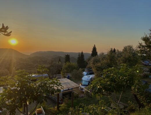 A view of the sun setting over a camp site.