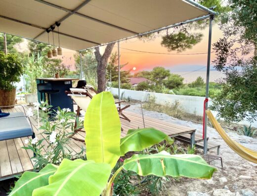 A hammock on a deck overlooking the sunset.