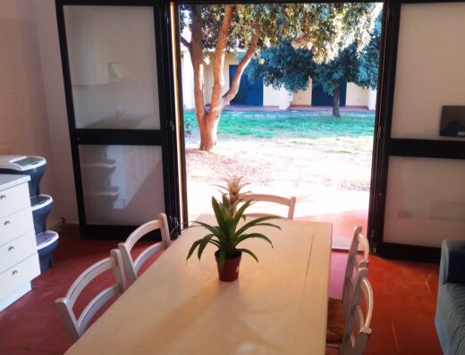 A dining room with a table and chairs in front of a door.
