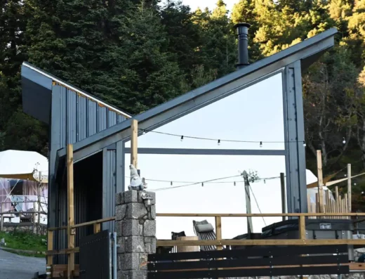 A building with a metal roof and a stone wall.