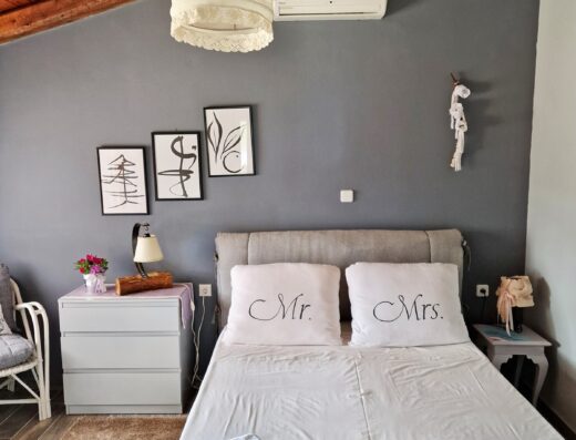 A bedroom with wooden ceilings and a white bed.