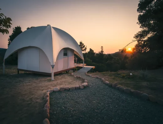 A white dome tent sits on top of a hill.