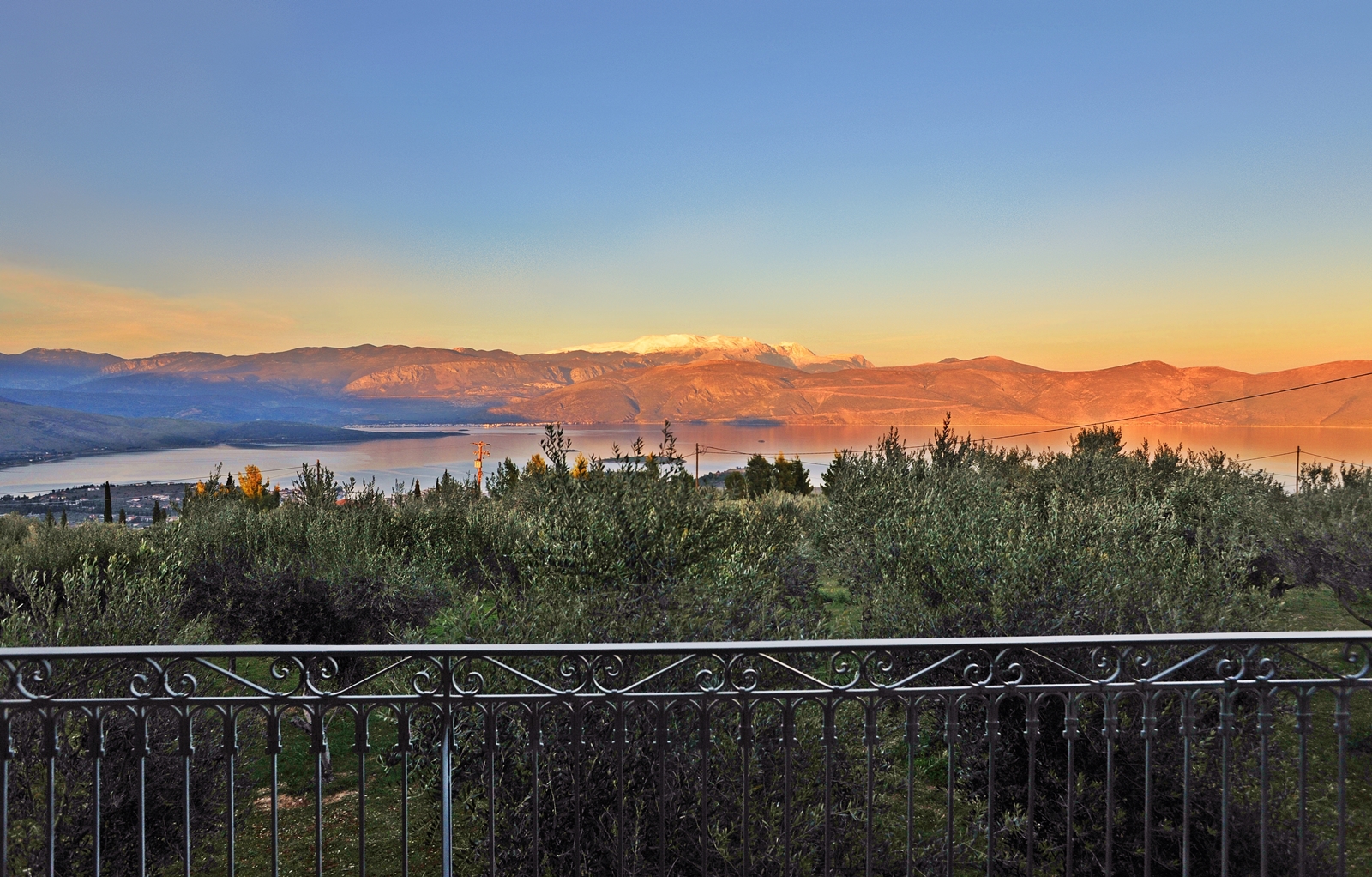 A view from a balcony overlooking a lake and mountains.