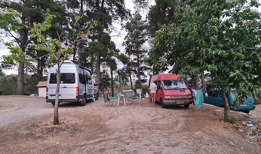 A group of rvs parked in a dirt lot.