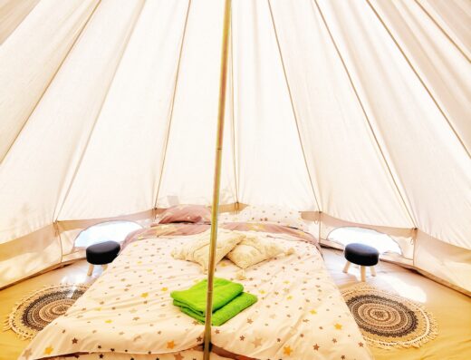 The inside of a tent with a bed and pillows.