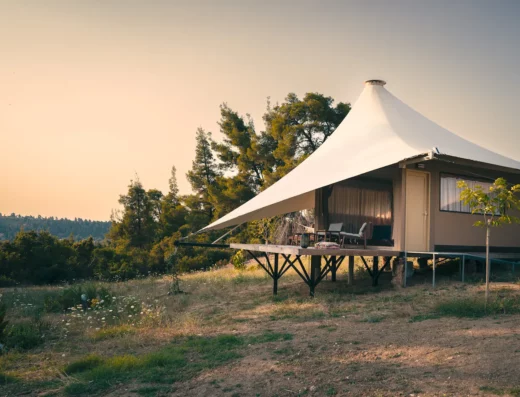 A tent on stilts with trees in the background.