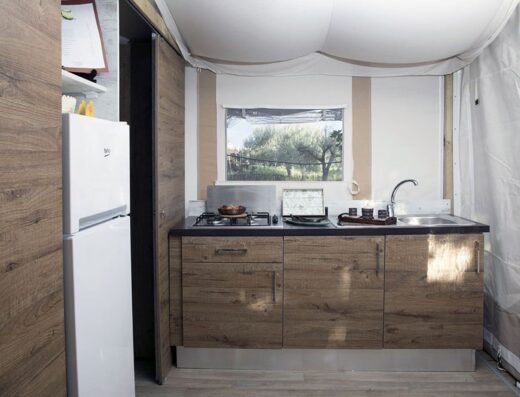 A small kitchen with wooden cabinets and a refrigerator.
