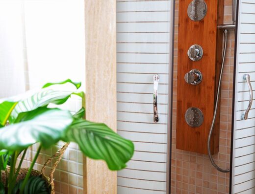 A wooden shower stall with a plant in it.