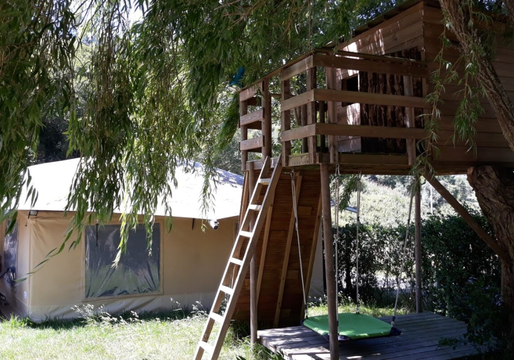 Discover South Europe's Gems with a tree house and an exclusive ladder next to it, offered by Campsaround.
