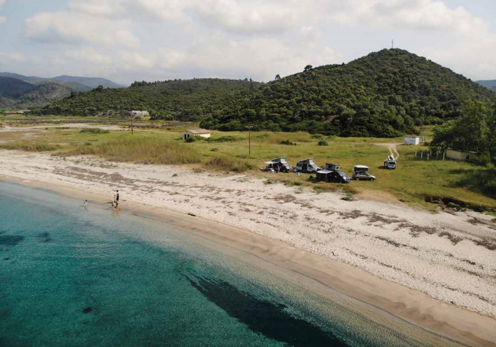 Discover South Europe's Gems: An aerial view of a beach with a boat in the water, brought to you exclusively by Campsaround's Adventure Travel Packages.